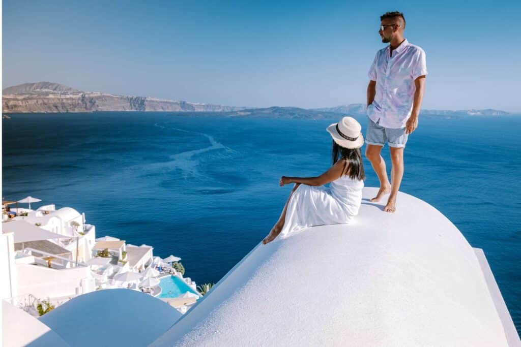 Couple standing on roof in Santorini