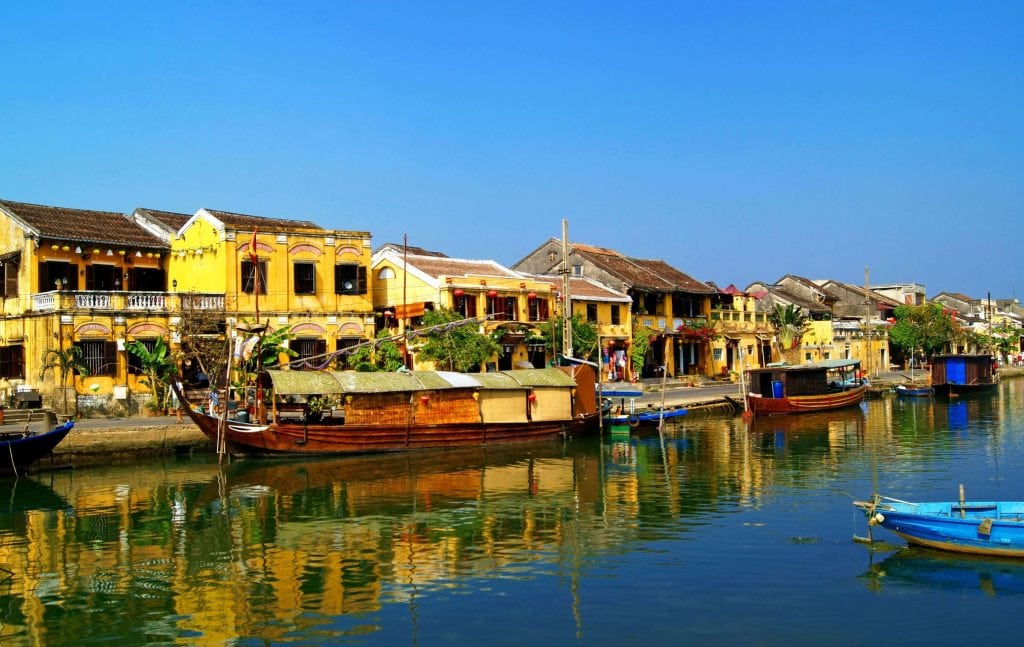 River in an old town in Hoi An Vietnam with trading boats and buildings